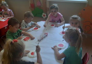 Zuzia, Witek, Miłosz, Zosia, Zosia i Nikola malują biedronki z talerzyków papierowych.